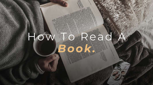 Experience the joy of reading with our banner image capturing a top view of a gentleman engrossed in a book, holding a coffee cup in his other hand.